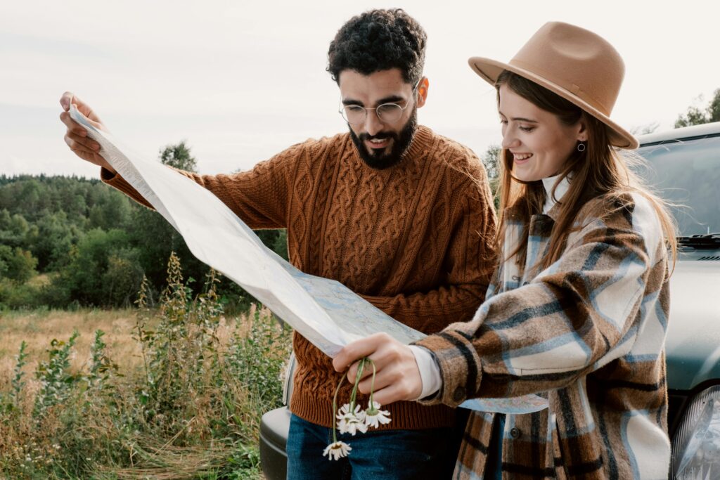 A couple in cozy attire examining a map for their outdoor adventure.